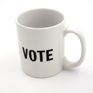 I Will Vote Mug, viewed from slightly above can read the word vote in black block letters on the standard cylindrical white mug