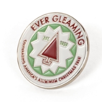 Round pin with a white band on the outer edge and red text reading "Ever Gleaming" on top and "Celebrating America's Aluminum Christmas Tree" below. The inner circle is green with a white starburst shape containing a red Christmas tree shape and the green text "Est. 1959".