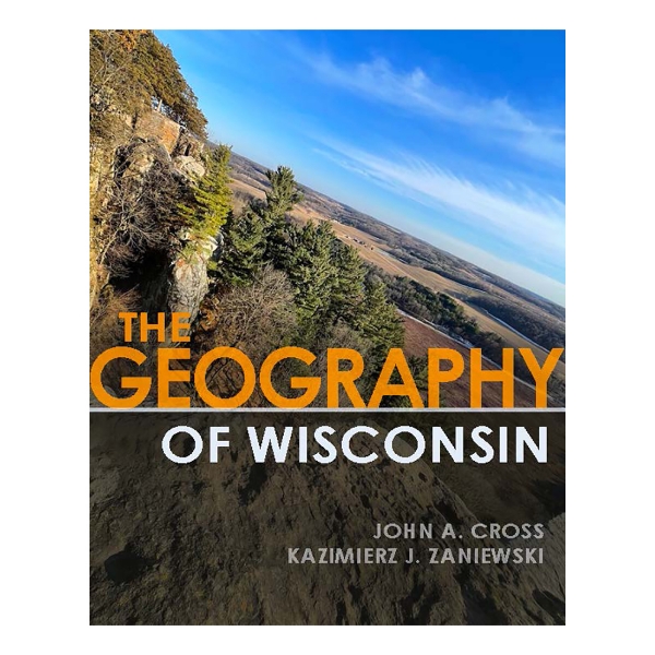 Book cover of "The Geography of Wisconsin" with the title in large font over a background photograph of a wooded, rocky hillside under a blue sky. 