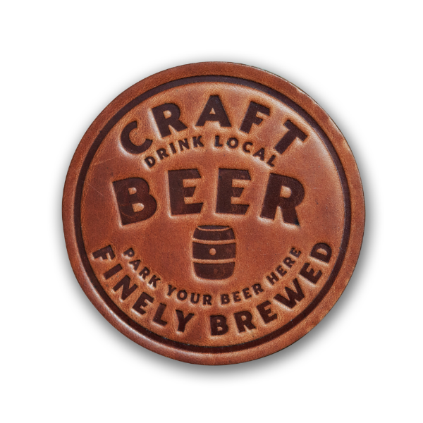 Round leather beverage coaster embossed with the words "Craft Beer Finely Brewed." Medium brown color.