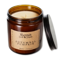 The Autumnal Pumpkin 16 oz candle in brown glass container with black tin screw top leaning on the side of container.