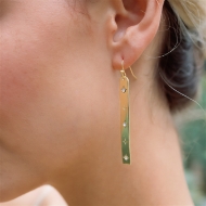 The Starry Long Studded Dangle Earrings - Gold on a woman's ears