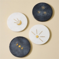 The Indukala Moon Phase Marble Coasters on a light yellow background 